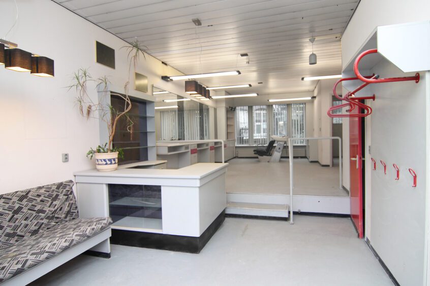 a white room with a red door and a white counter